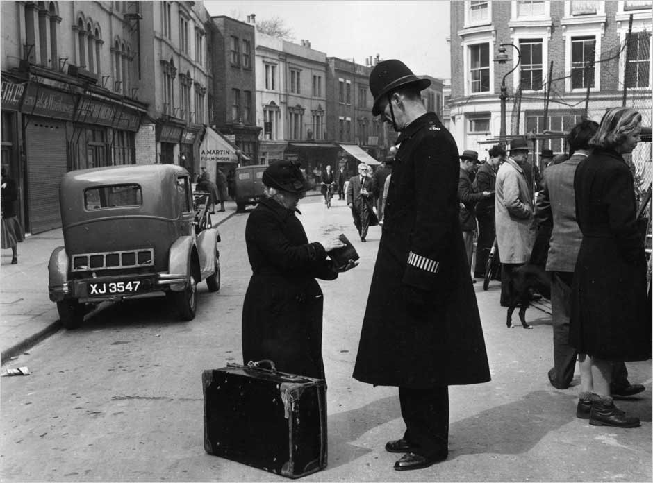 Полицейский помогает даме на Портобелло-Роуд в Лондоне, 1951. Автор Курт Хаттон