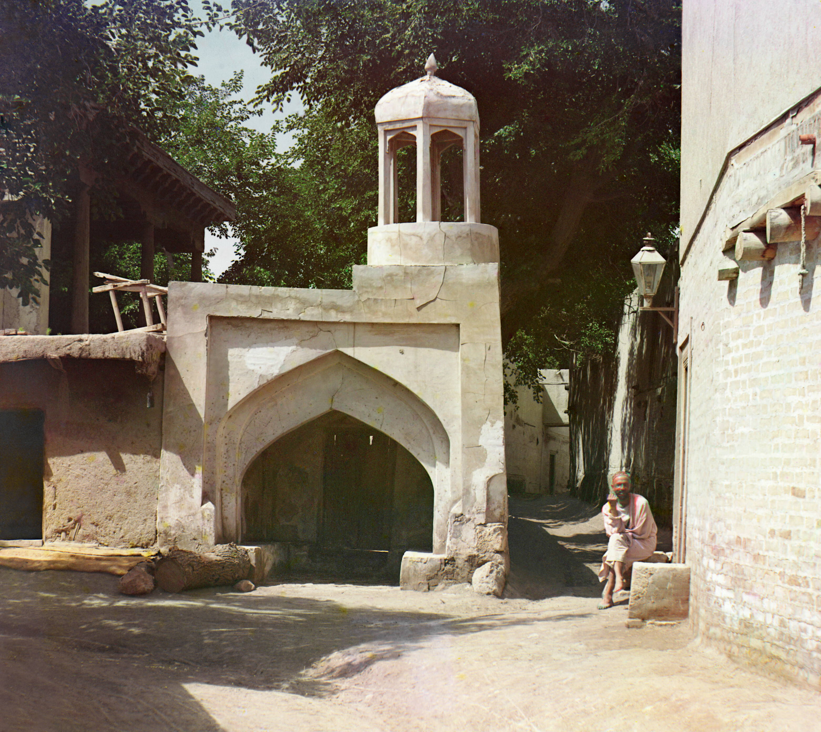 Мужчина сидит во дворе. Арочная башня на заднем плане, 1905-1915, фотограф Сергей Прокудин-Горский