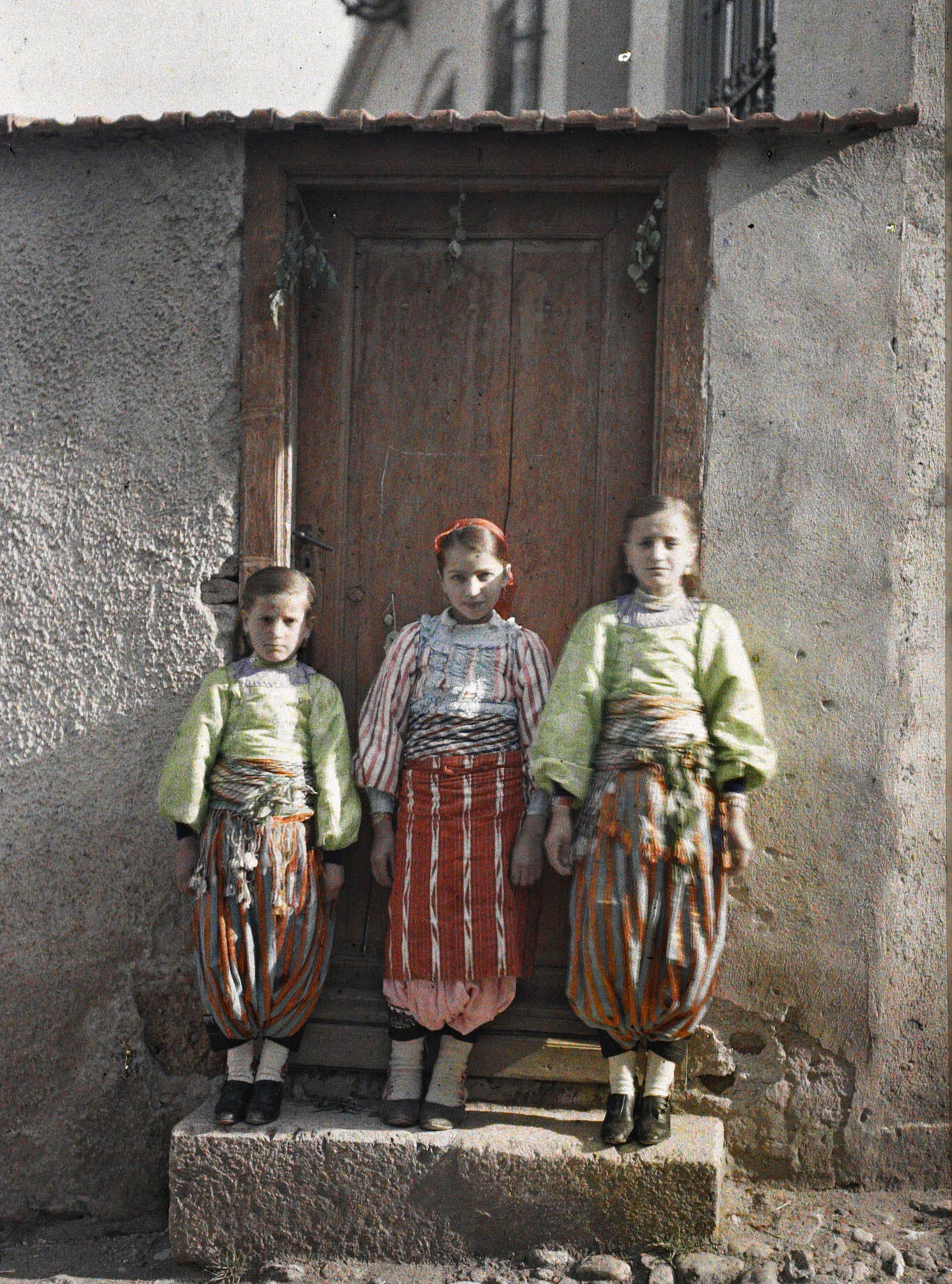 Призрен, Косово, Сербия. Три сербские девушки в дверях, 1913 год, автор Огюст Леон (автохром)