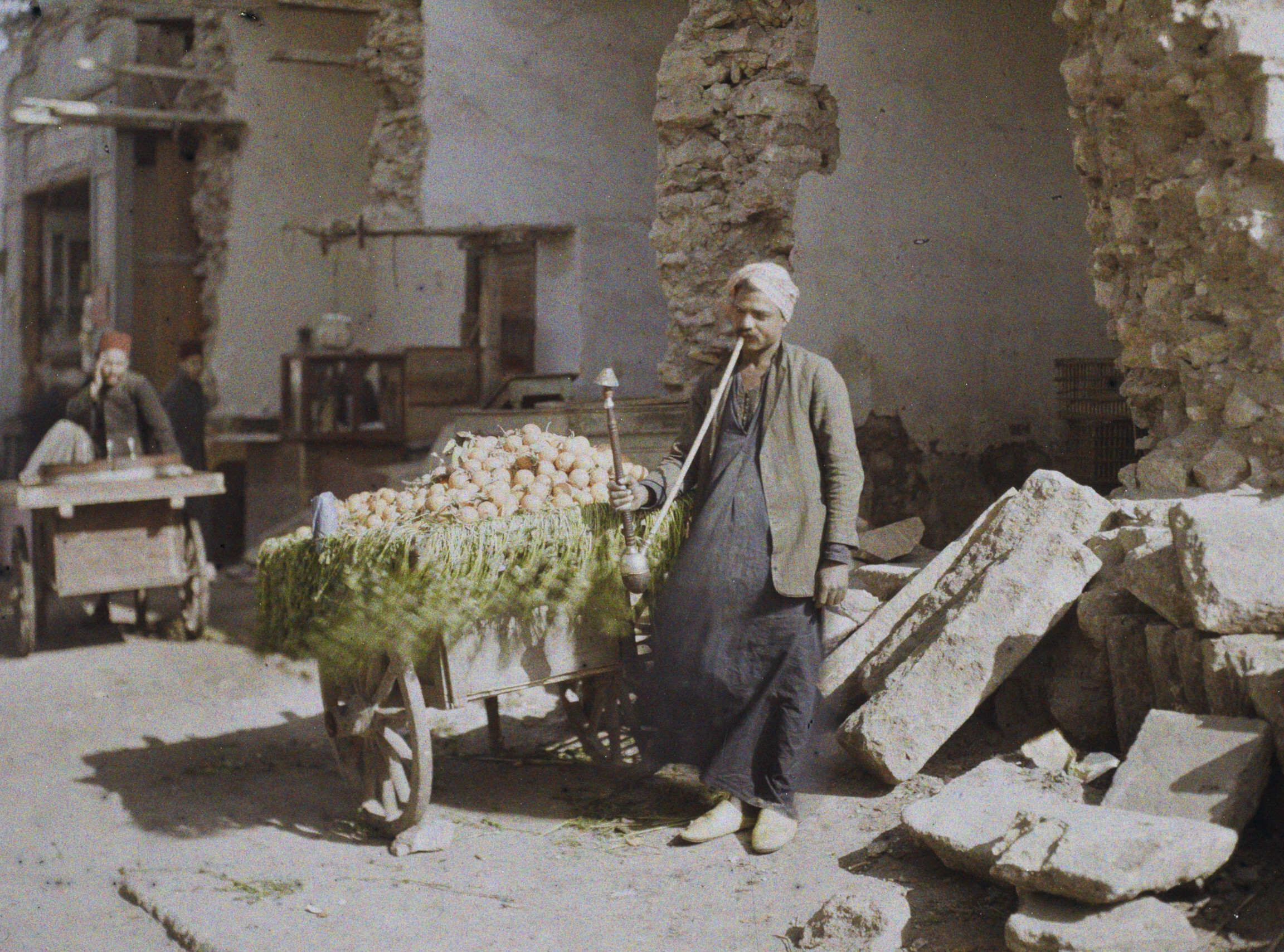 Каир, Египет. Уличный продавец апельсинов, курящий кальян, 1914 год, автор Огюст Леон (автохром)