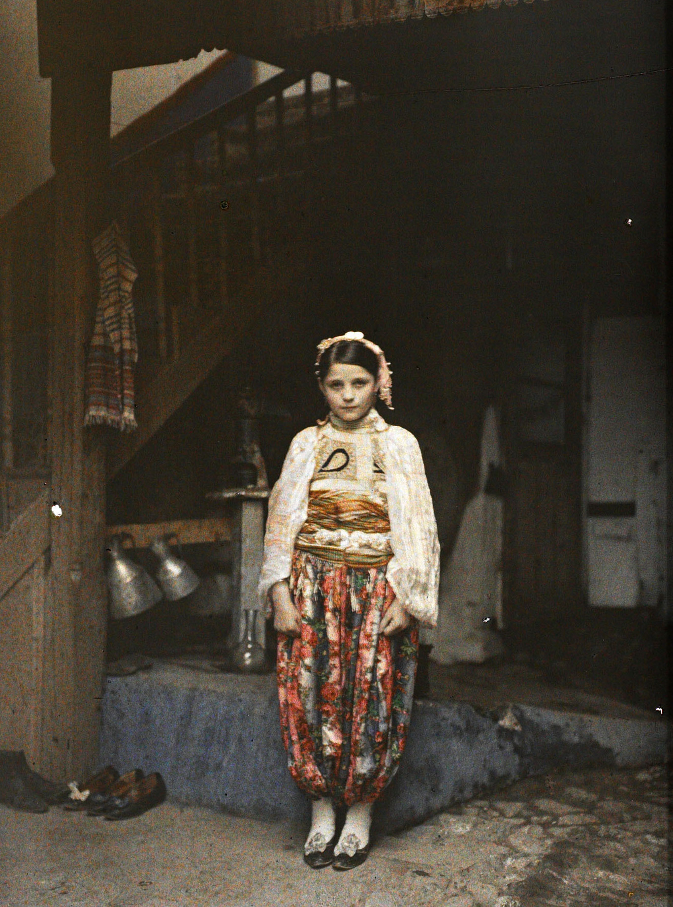 Призрен, Косово, Сербия. Cербская девочка в традиционном костюме во дворе дома, 1913 год, автор Огюст Леон (автохром)