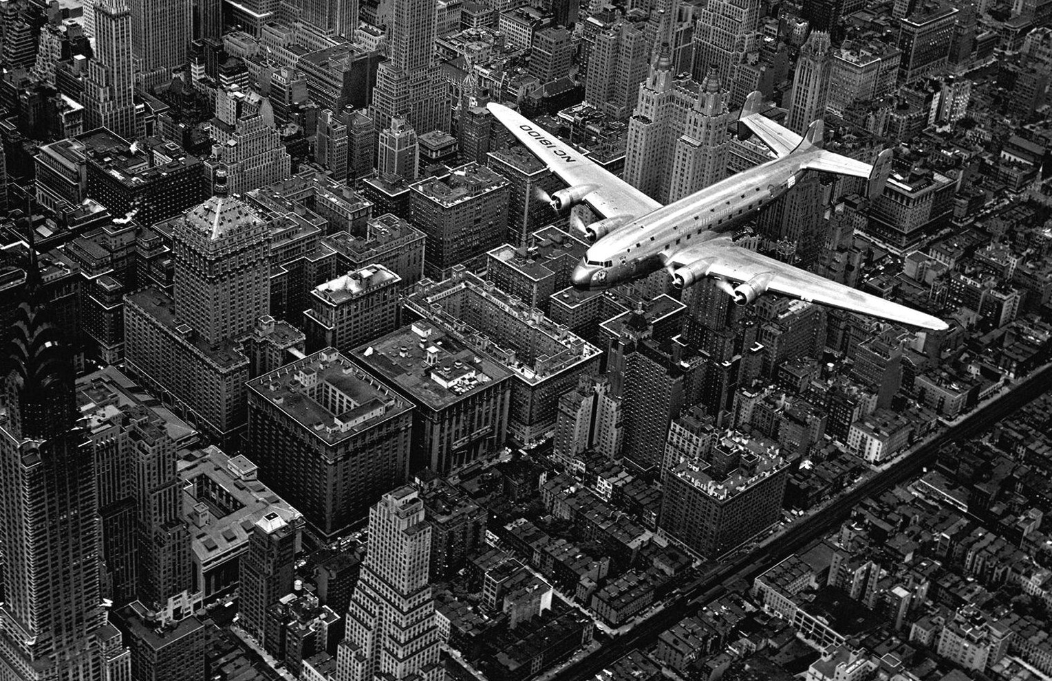 Самолет Douglas 4 (D-4) пролетает над Манхэттеном, Нью-Йорк, США, 1939 год, фотограф Маргарет Бурк-Уайт (Margaret Bourke-white)
