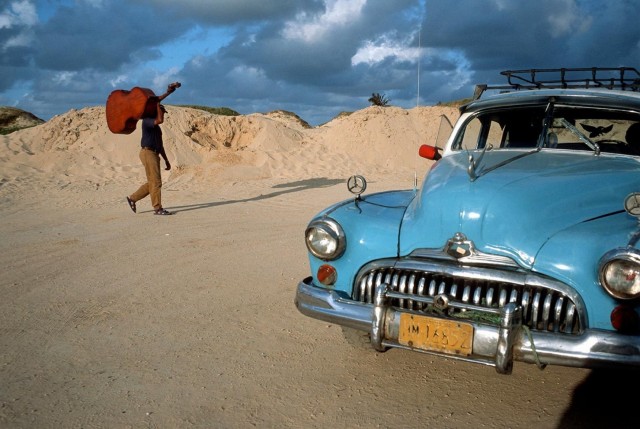 По пляжу бродит музыкант. Санта-Мария-дель-Мар, Гавана, Куба, 1998. @ Дэвид Алан Харви