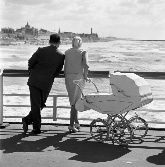 Супружеская пара с детской коляской в Схевенингене,  Нидерланды, 1961. Фотограф Хенк Йонкер