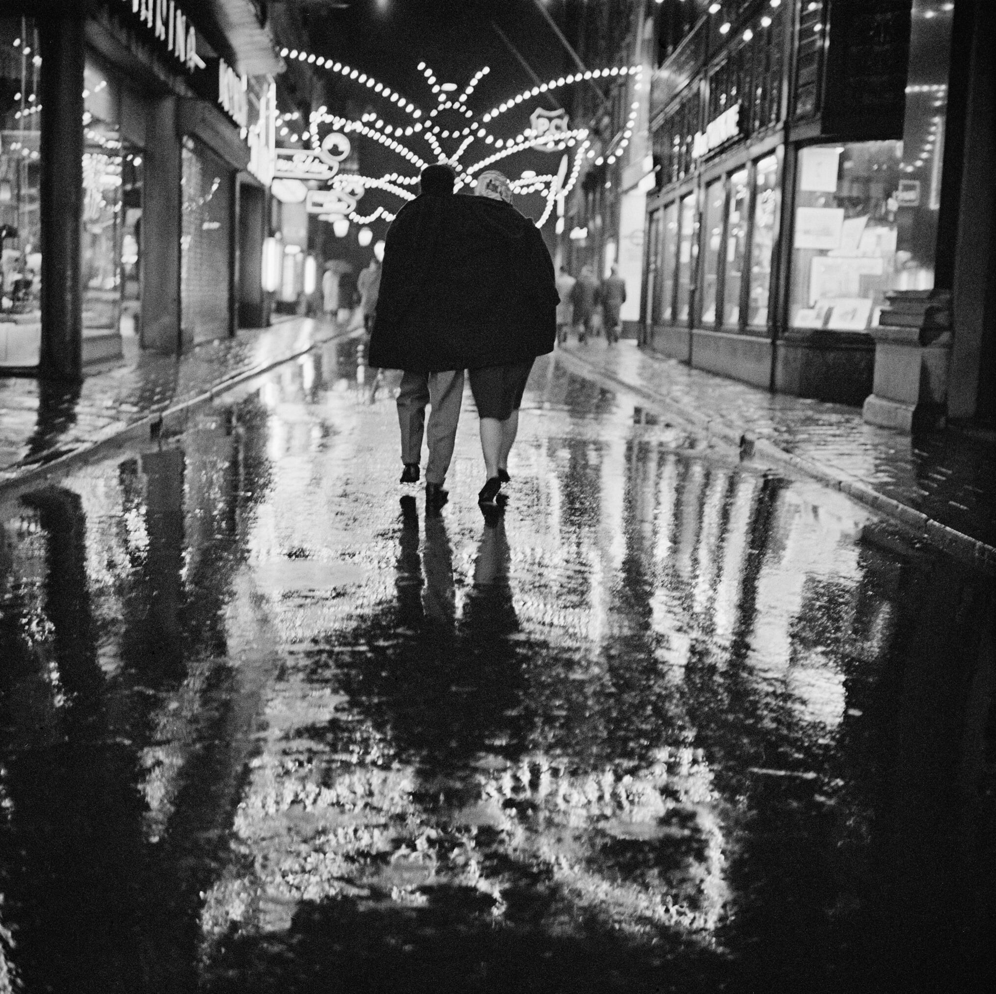 Пара, гуляющая под дождём на улице Калверстрат, Амстердам, 1950-е. Фотограф Кор ван Вееле