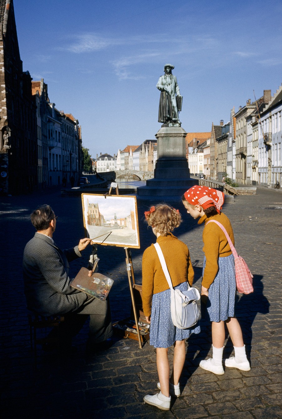 Художник пишет статую фламандского живописца в Брюгге, Бельгия, 1955. Фотограф Луис Марден