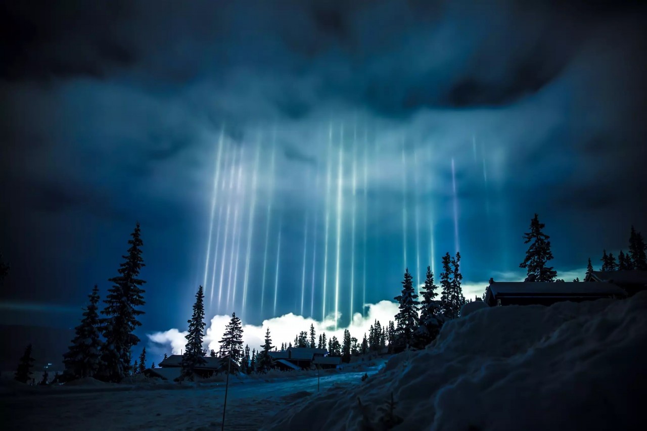 Столбы света, редкое явление, возникающее, когда микроскопические кристаллы льда в воздухе отражают свет. Фотограф Грег Томашевич
