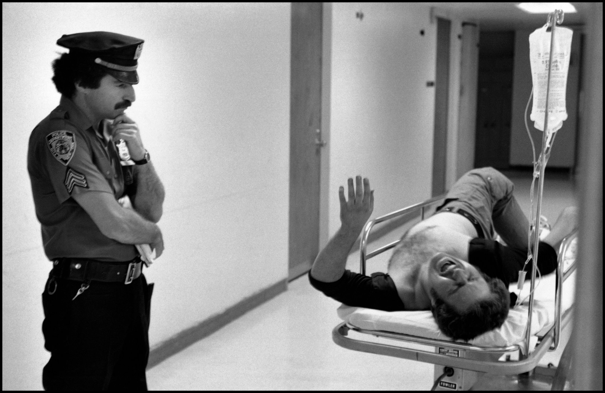Полицейский терпеливо ждет в отделении неотложной помощи больницы, пока жертва с ранением в ногу расскажет, что произошло, Нью-Йорк, 1978. Фотограф Леонард Фрид