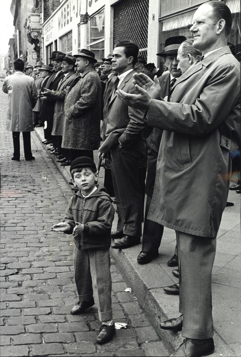 1 мая в день рабочего мужчины слушают ораторов на углу улицы, Дюссельдорф, Западная Германия, 1963. Фотограф Леонард Фрид