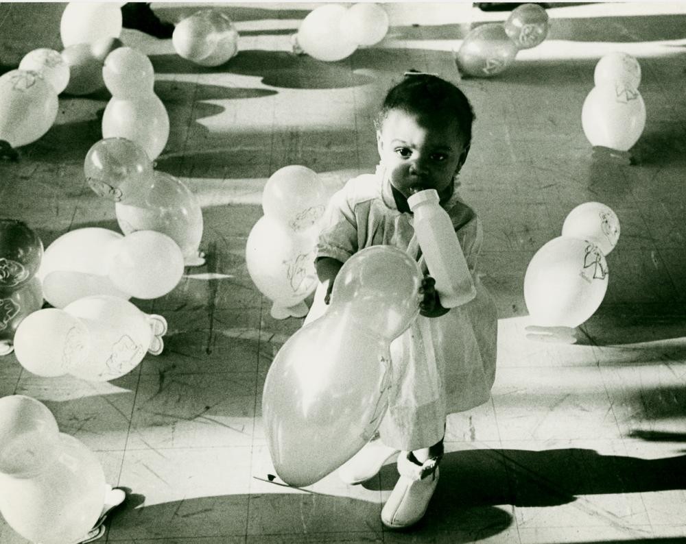 Ребенок в Гарлемской школе в окружении воздушных шаров. Фотограф Леонард Фрид