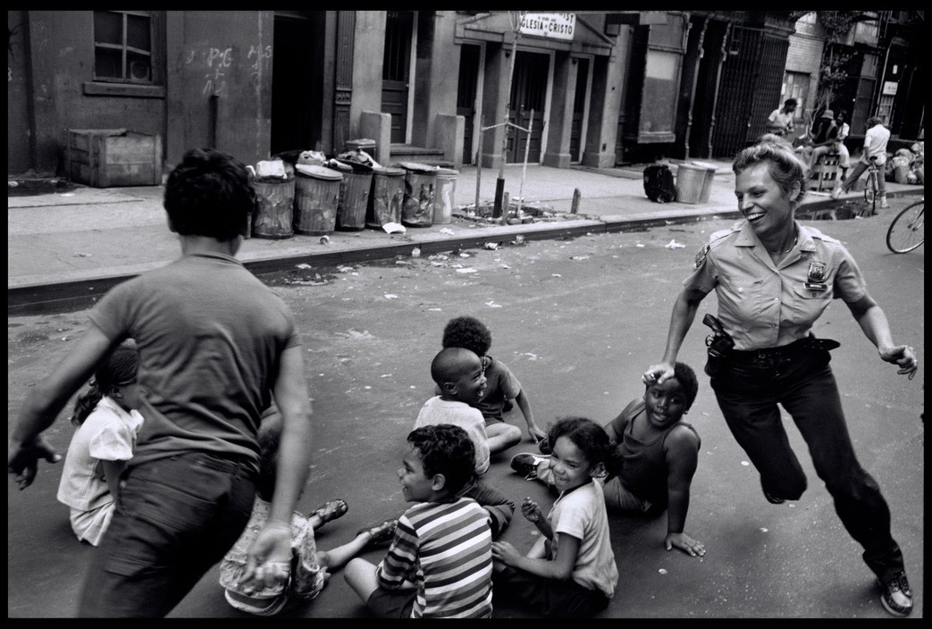 Женщина-полицейский играет с местными детьми в Гарлеме, Нью-Йорк, США. 1978. Фотограф Леонард Фрид