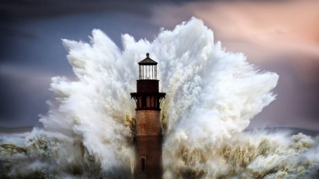 Огромная волна обрушивается на маяк. Фотограф Грег Уотерс