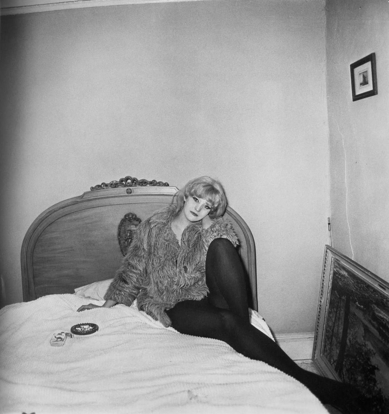 Девушка в пальто, лежа на кровати, Нью-Йорк, 1968. Фотограф Диана Арбус