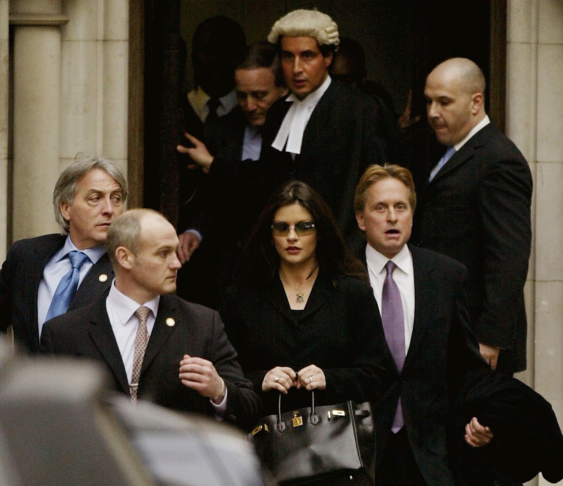 Кэтрин Зета-Джонс и Майкл Дуглас покидают здание суда в Лондоне, 2003. Автор Scott Barbour