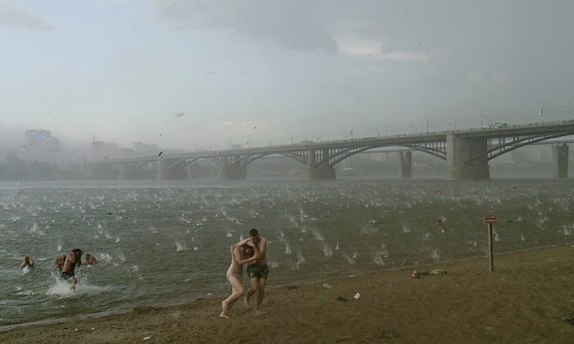 Люди спешат укрыться от града на пляже у реки Обь в Новосибирске, 2014. Автор Никита Дудник