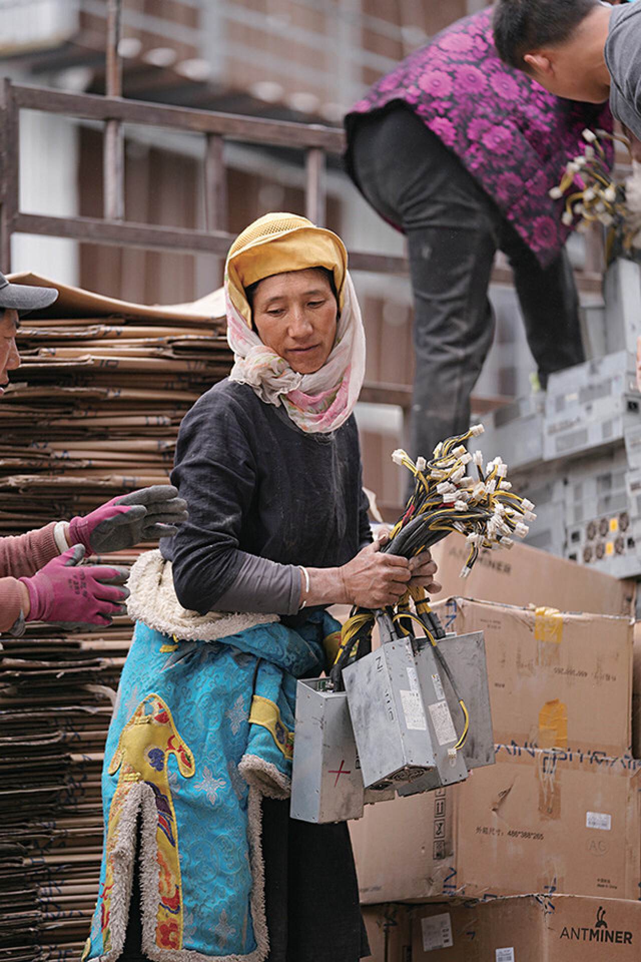 Тибетская женщина с блоками питания для майнинга криптовалют. Фотограф Ding Gang