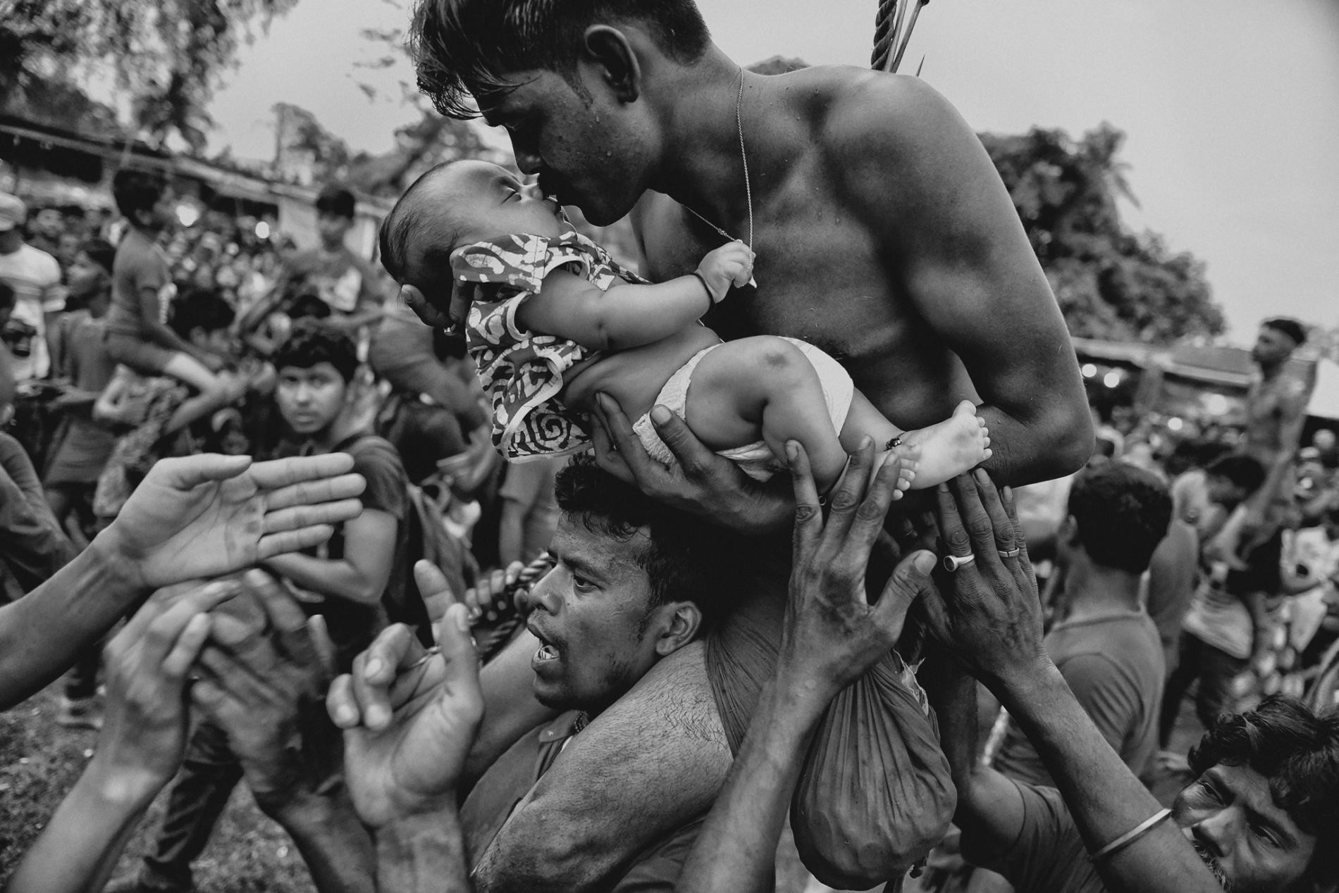 Индуист целует своего младенца во время праздника Чарак Пуджа в Западной Бенгалии, Индия. Автор Авишек Дас