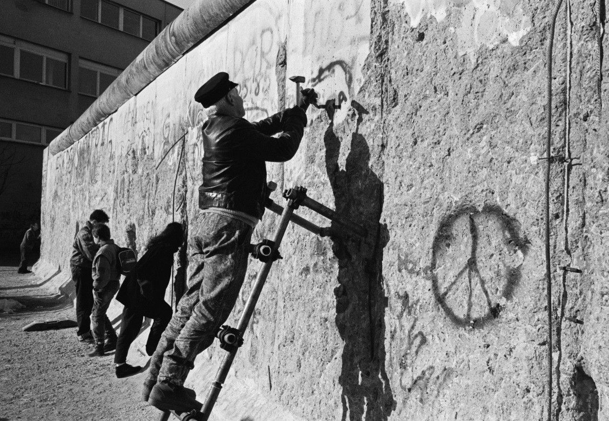 После падения Берлинской стены люди собирают куски стены в качестве сувениров, Берлин, Восточная Германия,1990 год. Фотограф Томас Хёпкер