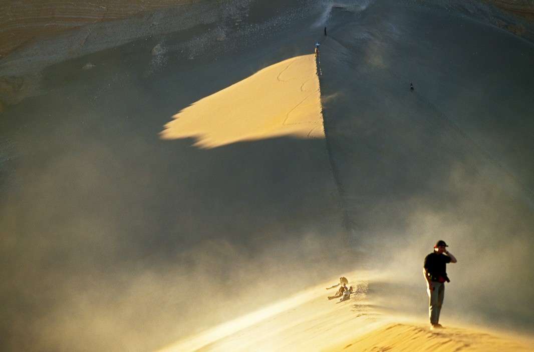 Люди взбираются на дюну на закате, пустыня Атакама, Долина Луны, Чили. Фотограф Томаса Хёпкер