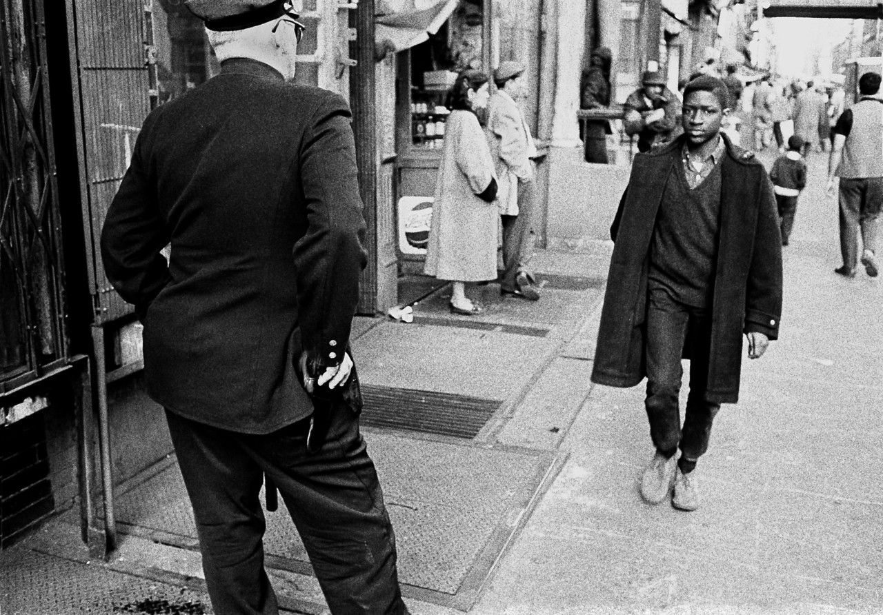 Нью-йоркский полицейский наблюдает за темнокожим подростком в Гарлеме, 1960 год. Фотограф Томас Хёпкер