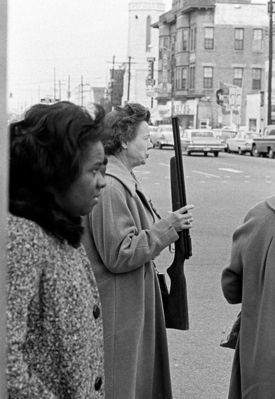 Женщина переходит улицу, держа в руках ружье, Техас, США, 1963 год. Фотограф Томас Хёпкер