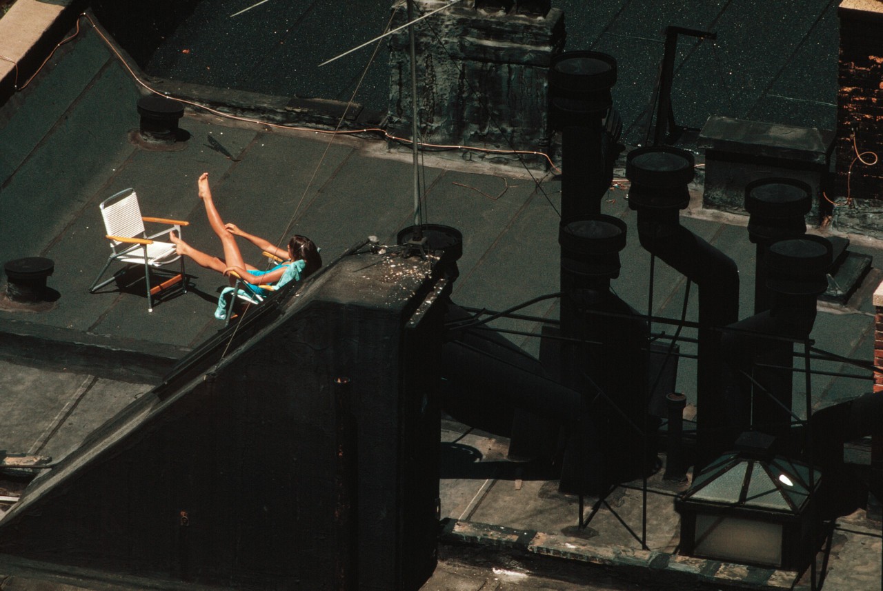 Девушка загорает на крыше Манхэттена, Нью-Йорк, 1983 год. Фотограф Томас Хёпкер