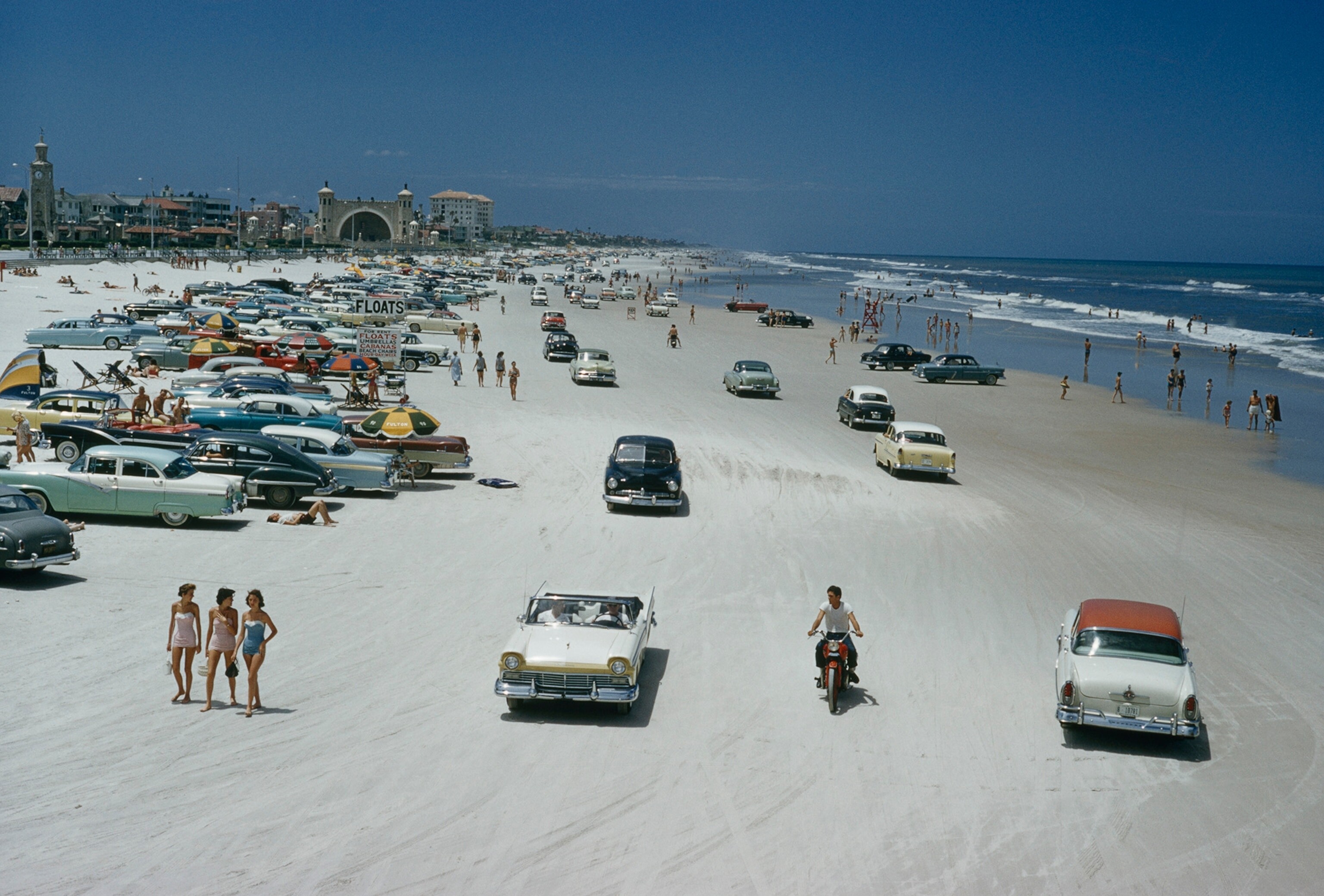 Автомобили, мотоциклы и любители позагорать на пляже в Дейтона-Бич, штат Флорида. Фотограф Дж. Бейлор Робертс