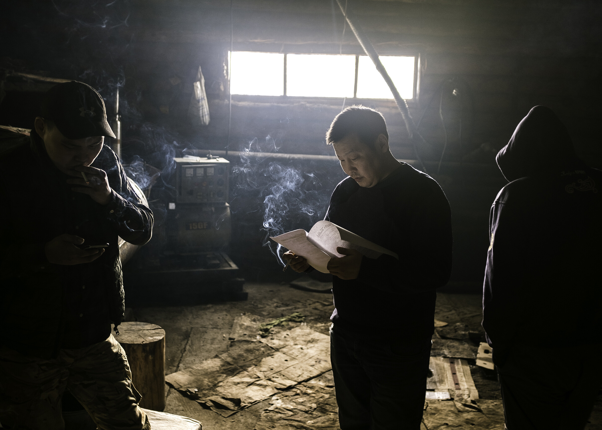 Актёры, играющие роли дальнобойщиков в драме «Чёрный снег», репетируют в курилке придорожного кафе, где проходит съёмка. Фотограф Алексей Васильев