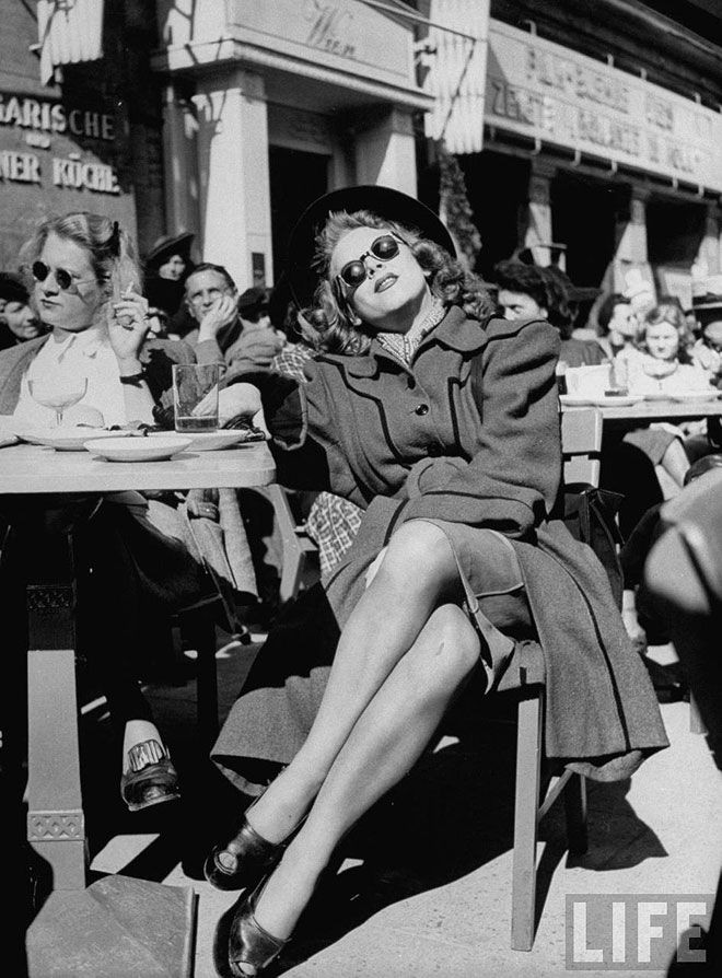 Люди греются в лучах солнца, сидя в кафе на тротуаре. Берлин, Германия, 1946. Уолтер Сандерс