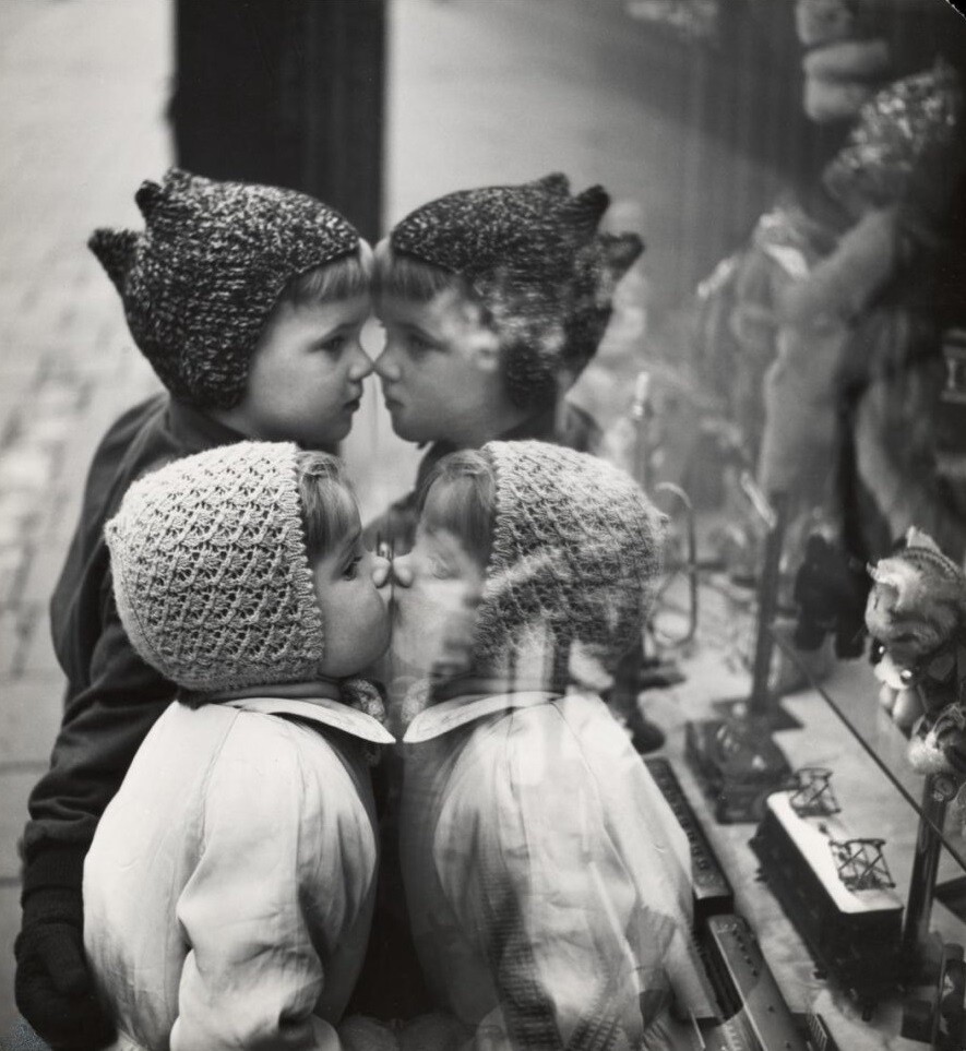Дети смотрят в стекло витрины, примерно 1950-е годы. Фотограф Виктор Мееуссен