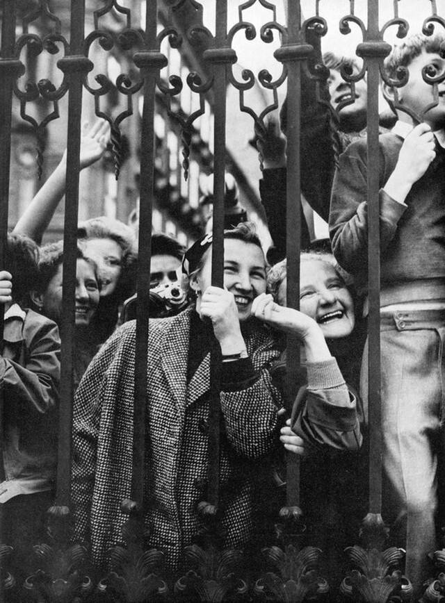 Люди ликуют у ворот дворцового комплекса Бельведер в честь подписания Австрийского государственного договора 15 мая 1955 года. Фотограф Франц Хубманн