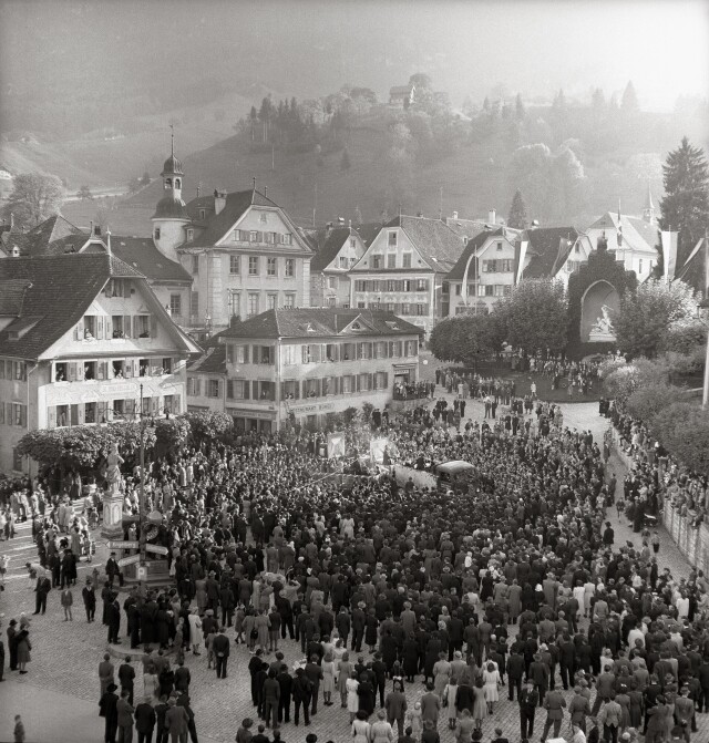 Толпа людей и памятник Винкельриду на площади города Штанс, кантон Нидвальден, Швейцария, 1940-е. Фотограф Леонард фон Матт