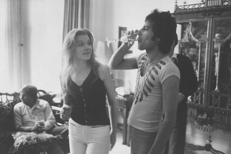 Фредди Меркьюри пьет шампанское, рядом – Мэри Остин, его бывшая девушка, вечеринка для друзей, 1977 год