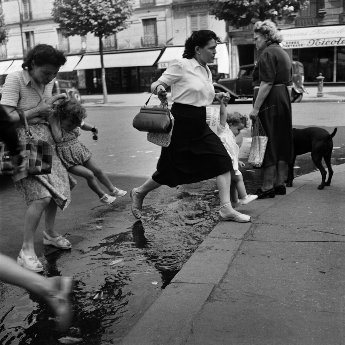 Пешеходы, прыгающие через лужу. Париж, ок. 1950. Фотограф Торе Джонсон