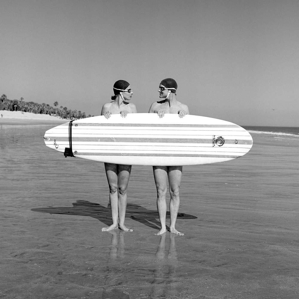 Мужчина и женщина с доской для сёрфинга. Автор Родни Смит