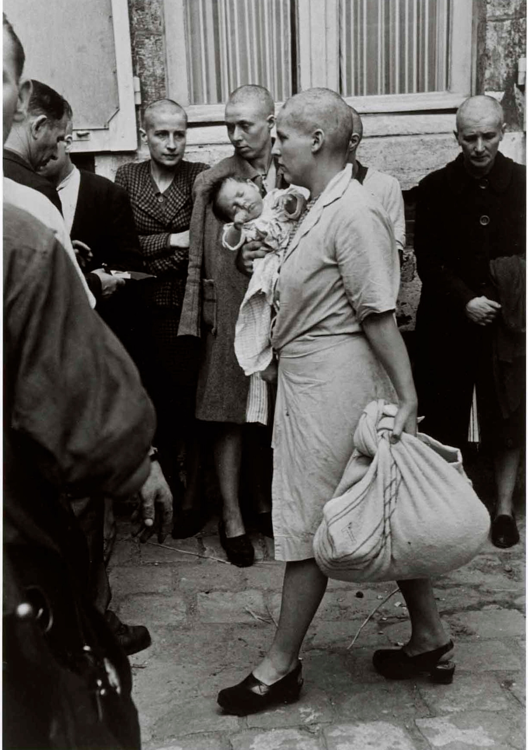 Французская женщина с ребенком, которого она родила немецкому солдату, была наказана бритьем головы, Шартр, Франция, 18 августа 1944 год. Фотограф Роберт Капа