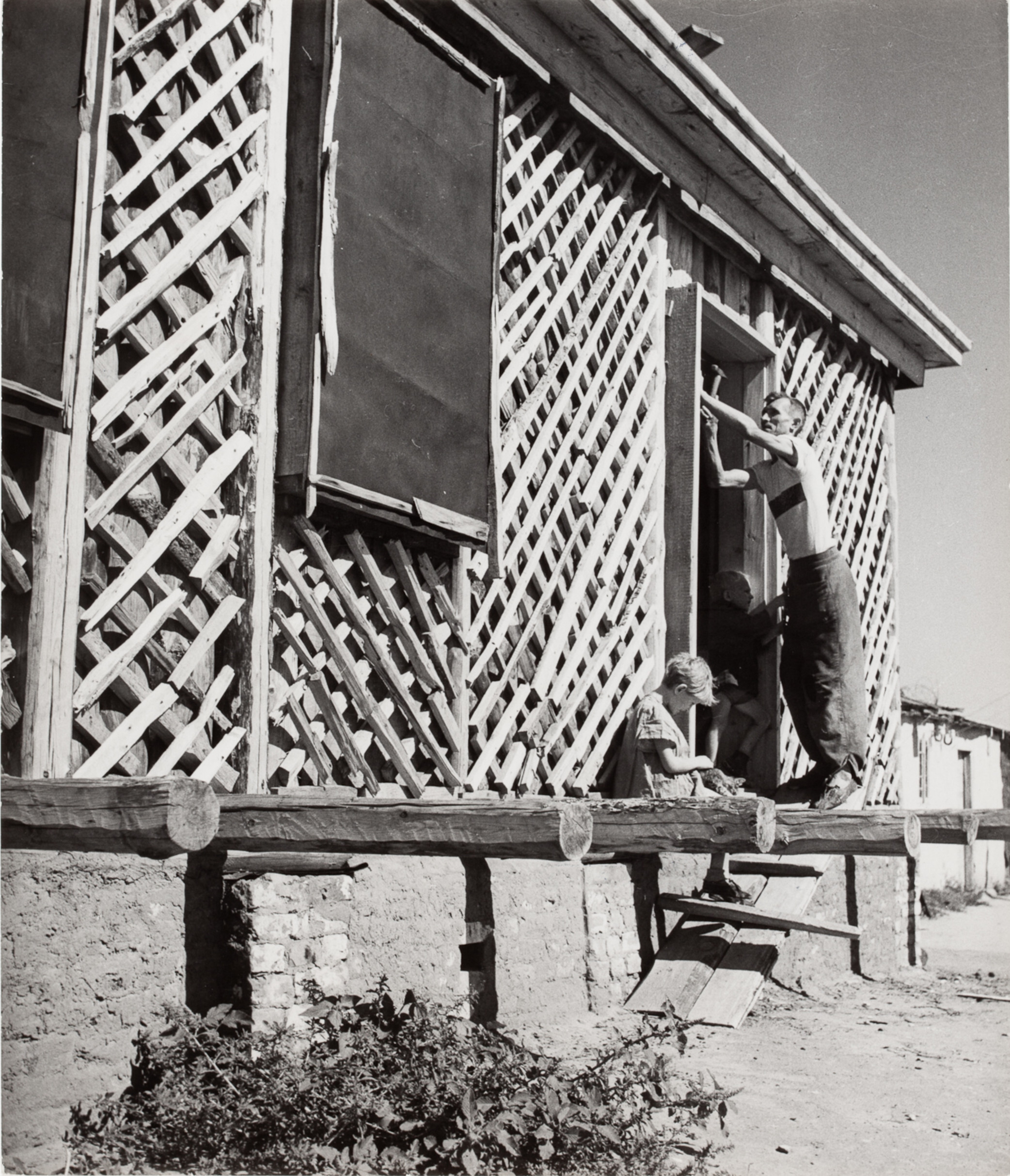 Мужчина строит дверь в новом доме, Сталинград, СССР, 1947 год. Фотограф Роберт Капа