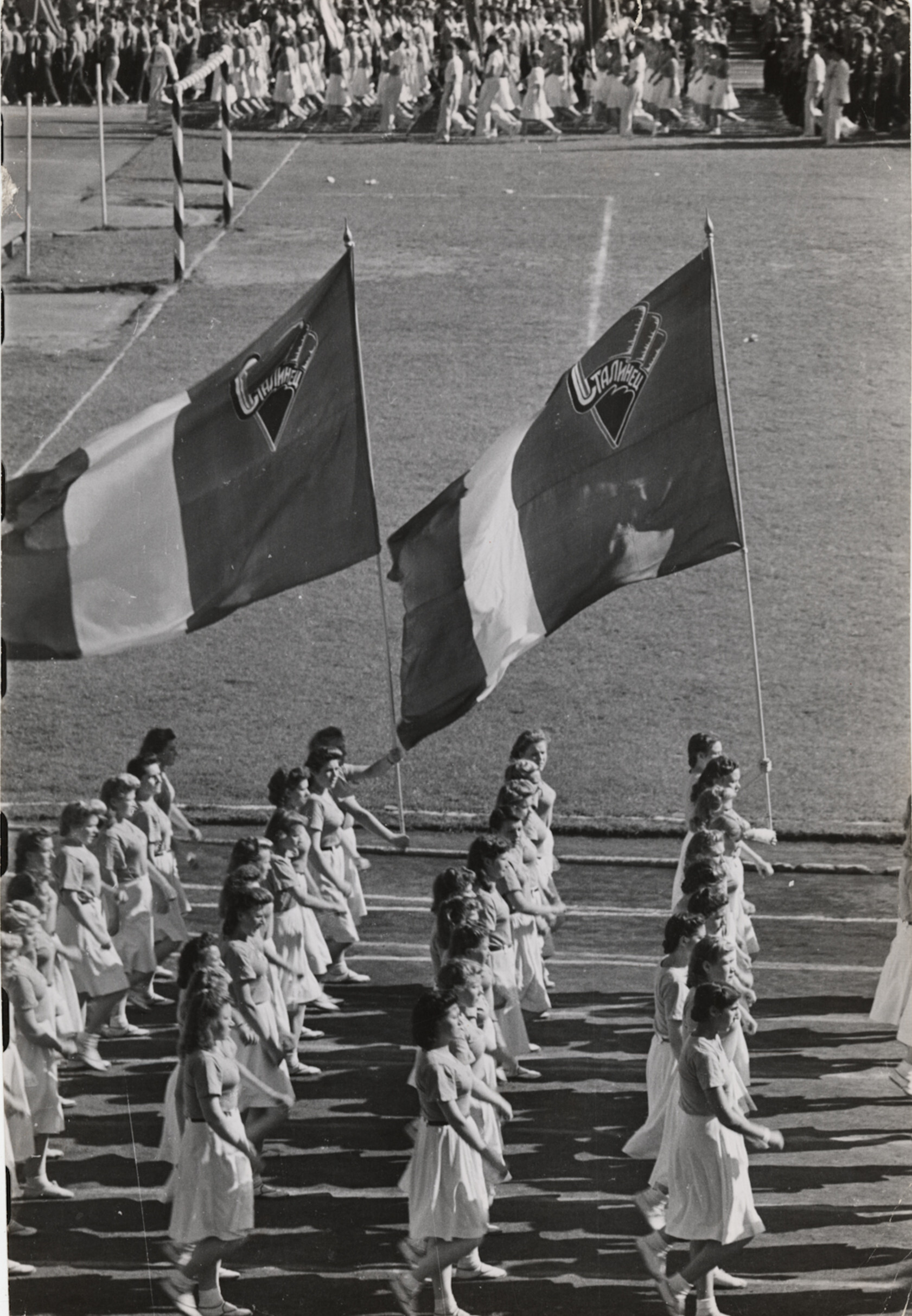 Спортсмены маршируют вокруг стадиона Динамо с флагами перед началом шоу, посвященного празднованию годовщины Москвы, Москва, 1947 год. Фотограф Роберт Капа