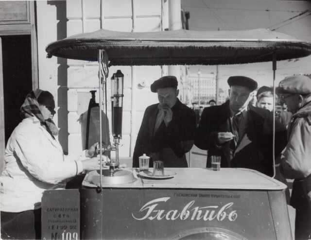 Женщина разливает напитки покупателям у тележки, Москва, 1947 год. Фотограф Роберт Капа