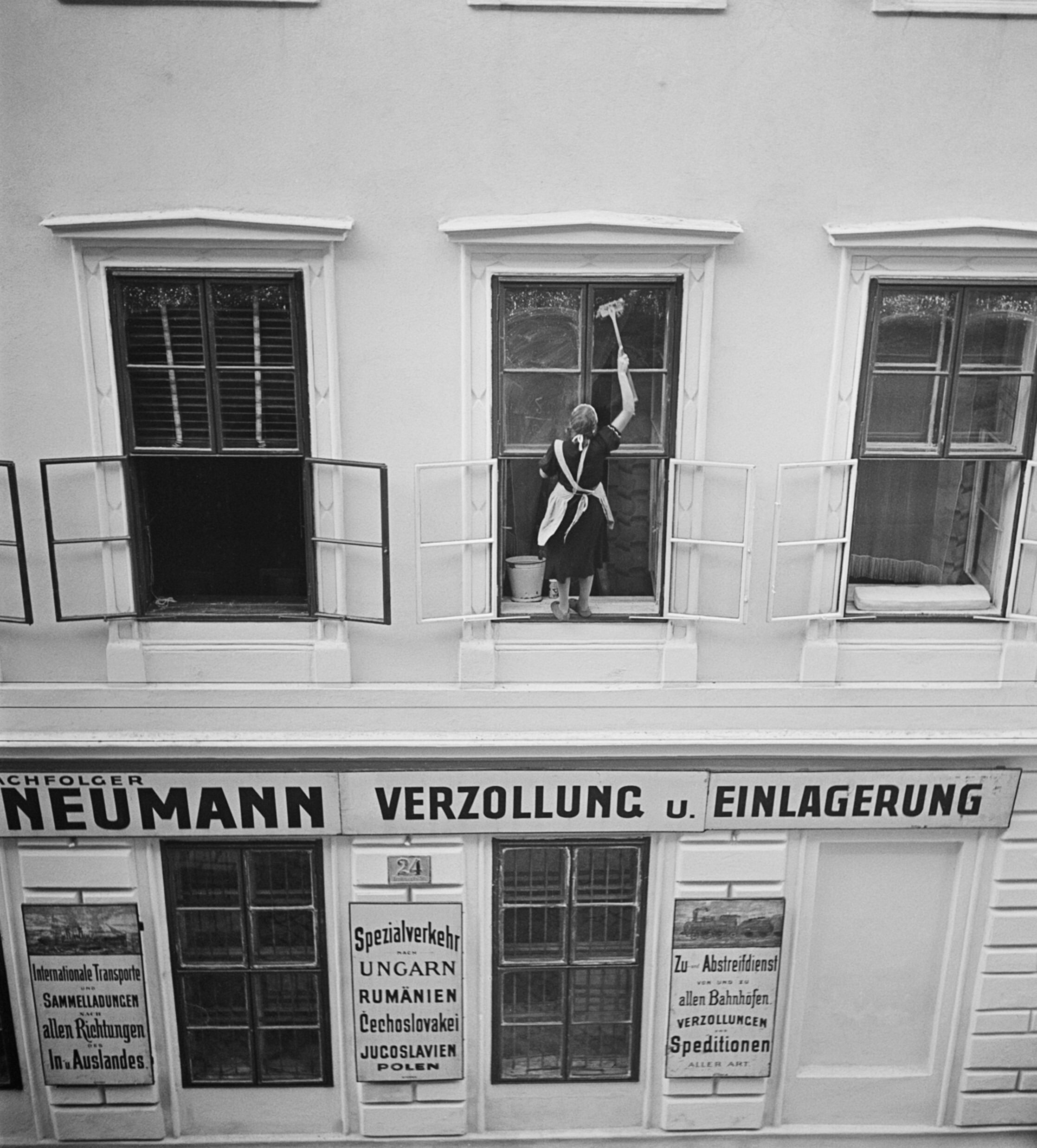 Женщина моет окна над Nachfolger Mandtler Neumann Speditionen (экспедиторские агенты Mandtler Neumann), Фердинандштрассе, Леопольдштадт, Вена, 1930-е годы. Фотограф Роман Вишняк