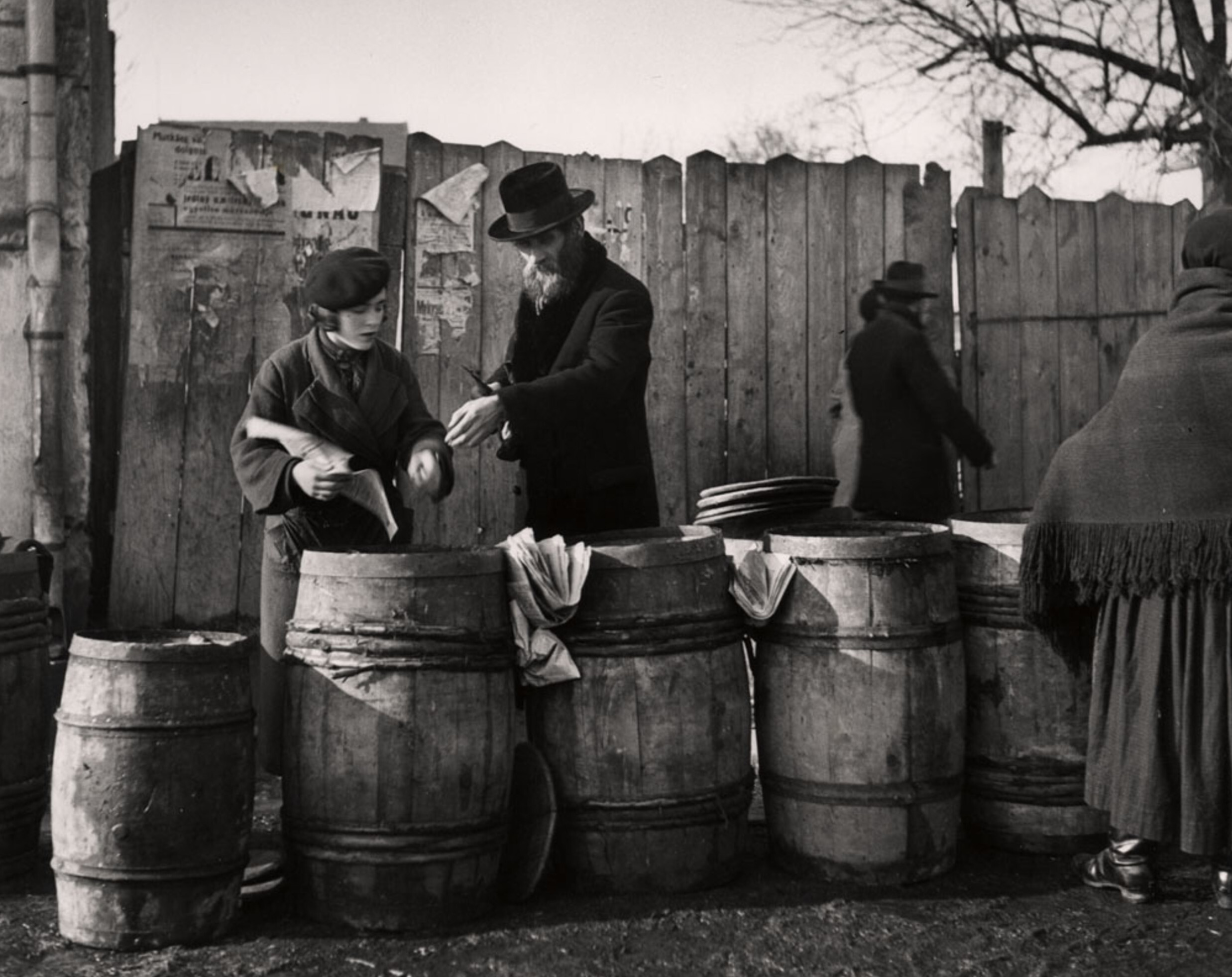 Мужчина покупает селедку, завернутую в газету, для субботней трапезы, Мукачево, ок. 1935-38 гг. Фотограф Роман Вишняк