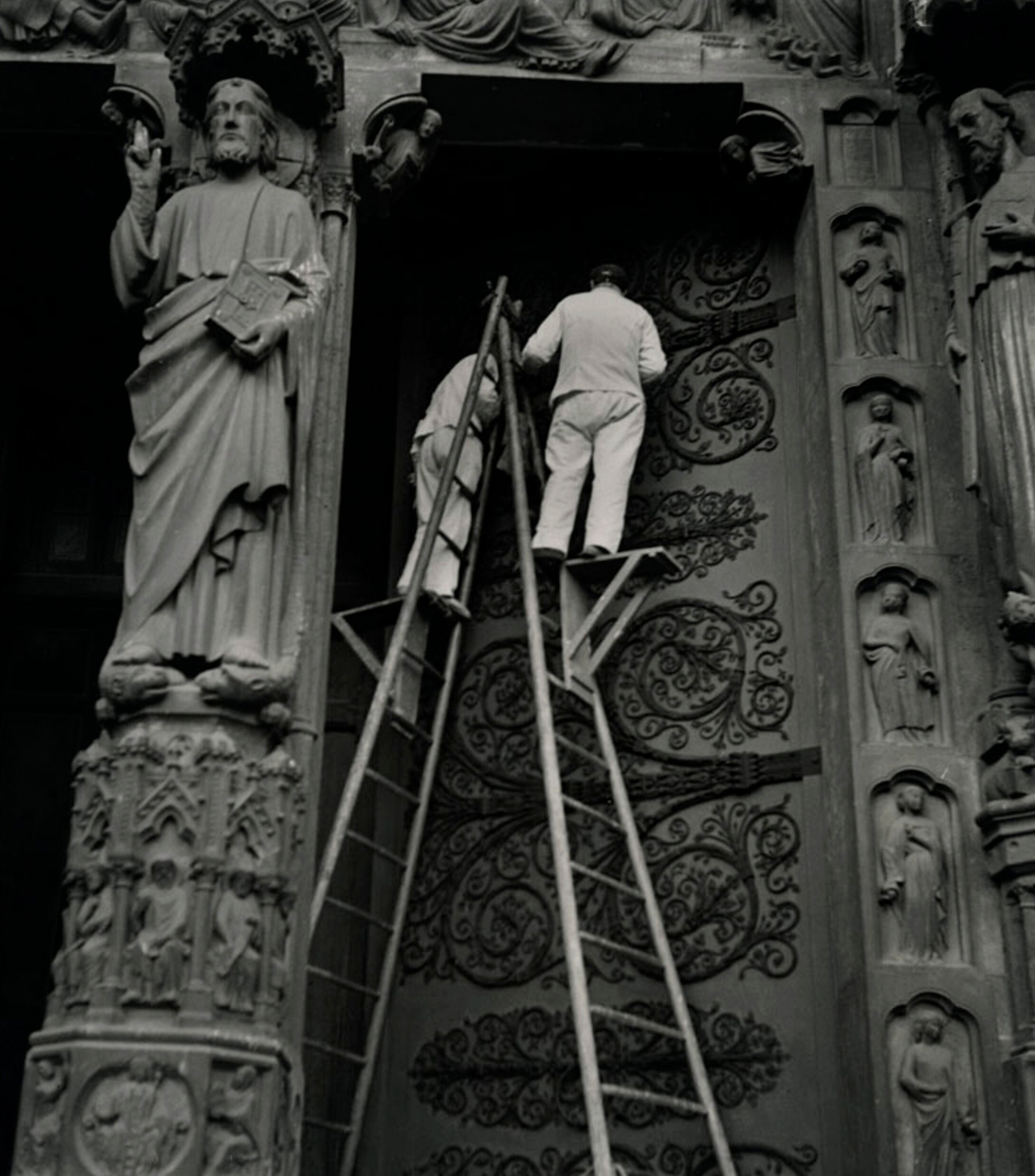 Мужчины чистят двери западного портала Нотр-Дам, Париж, ок. 1936-39 гг. Фотограф Роман Вишняк