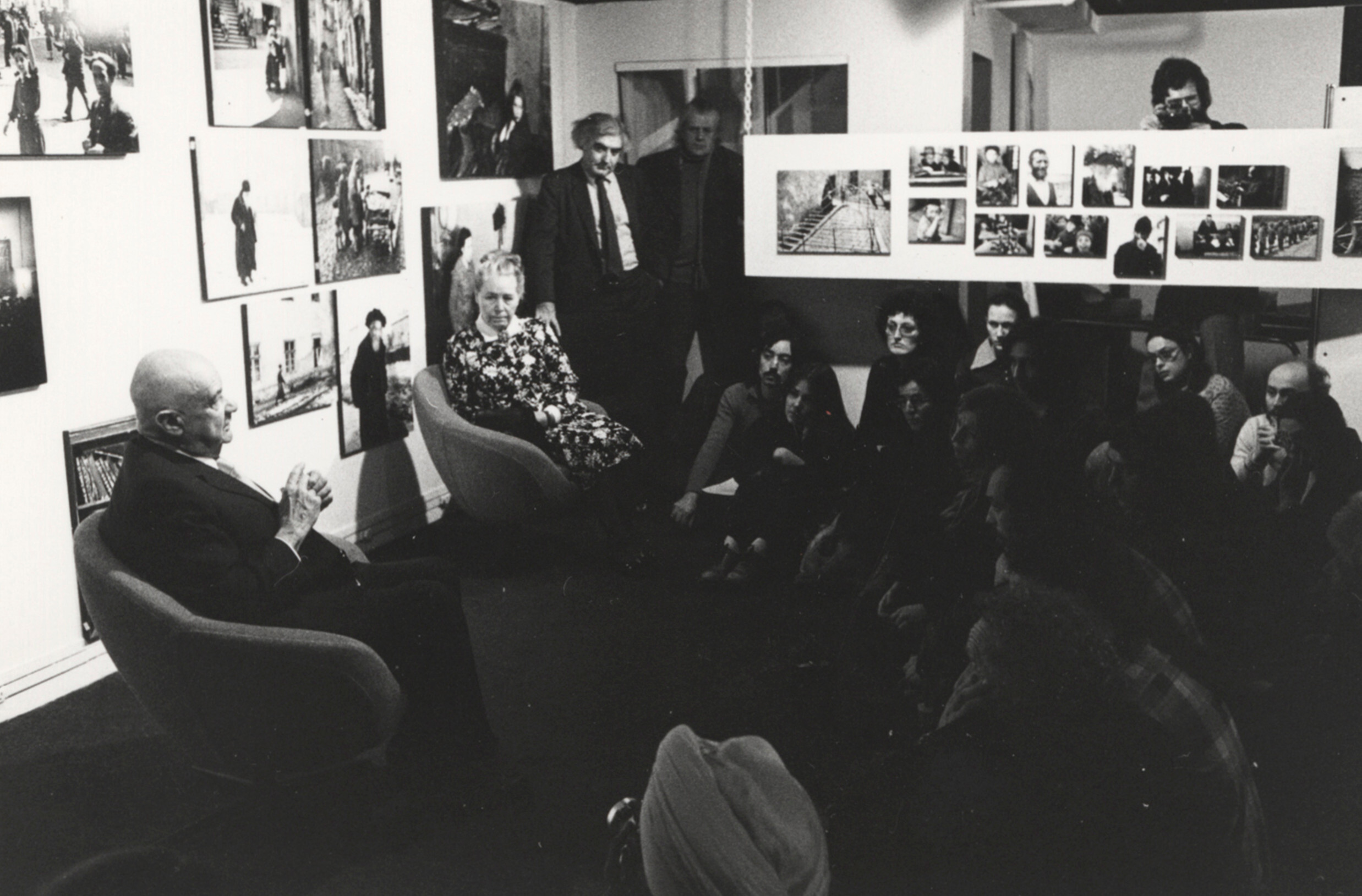 Роман и Эдит Вишняк с Корнеллом Капой (стоит) отвечают на вопросы на выставке The Concerned Photographer, Международный центр фотографии, Нью-Йорк, 1973 г. Фотограф Роман Вишняк