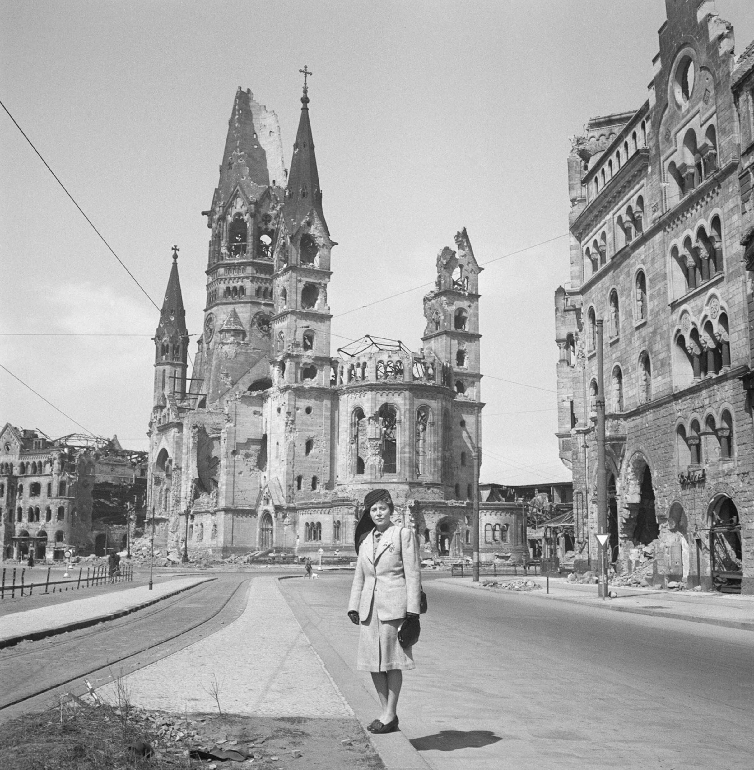 Эдит Эрнст Вишняк стоит перед Мемориальной церковью кайзера Вильгельма, угол Марбургерштрассе и Тауэнцинштрассе, Берлин, 1947 год. Фотограф Роман Вишняк