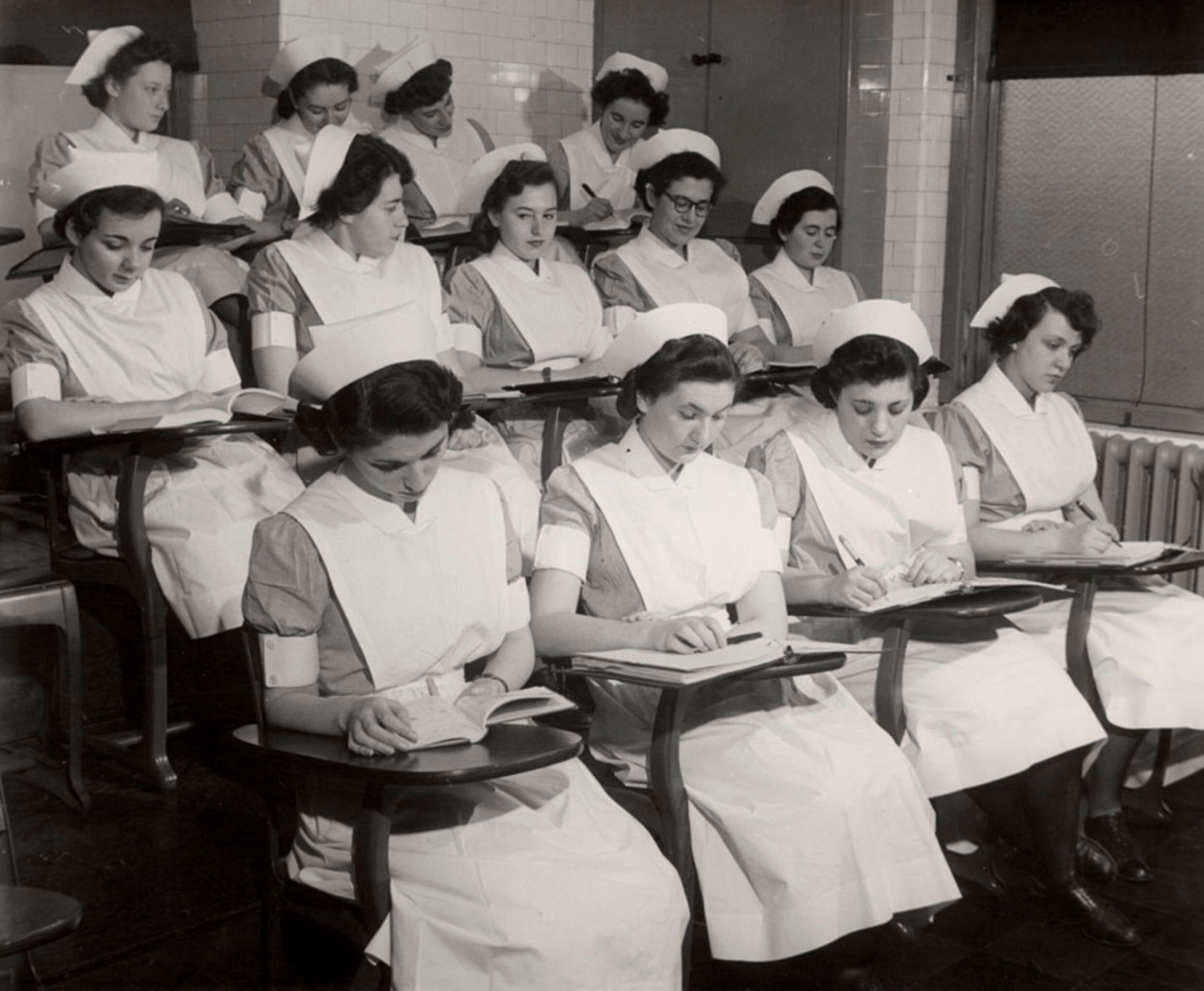 Первокурсники-медсестры, в том числе несколько переживших Холокост, в классе, Школа медсестер Бет Исраэль, Нижний Ист-Сайд, Нью-Йорк, ок. 1949 г. Фотограф Роман Вишняк