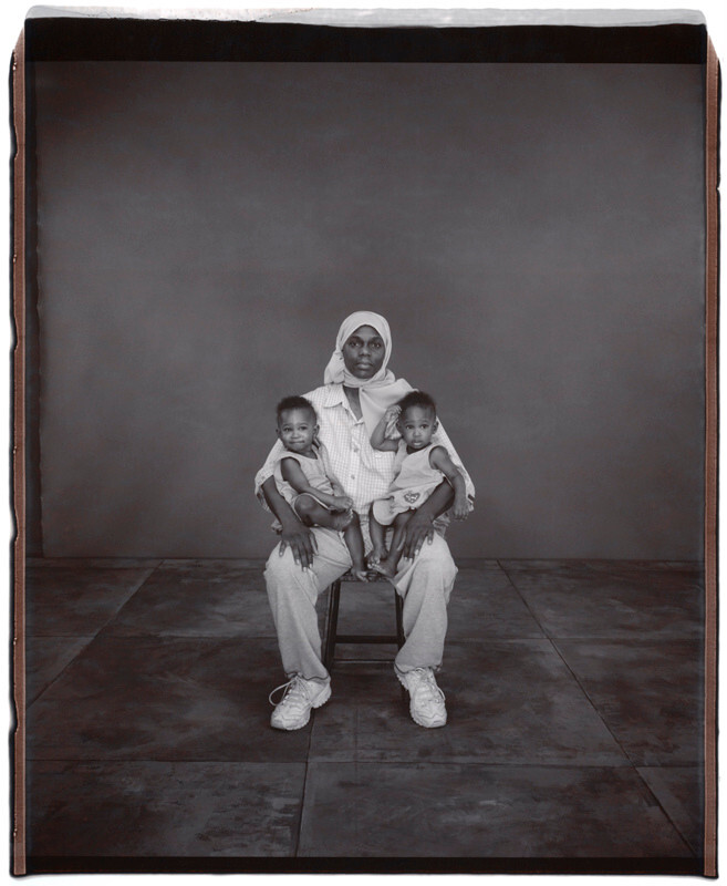 Хадиджа Хаким держит на руках Ясмину и Ясрию Али, 1 год, Ясмина старше на 6 минут, Твинсбург, Огайо, 2002 г. Фотопроект «Близнецы». Фотограф  Мэри Эллен Марк