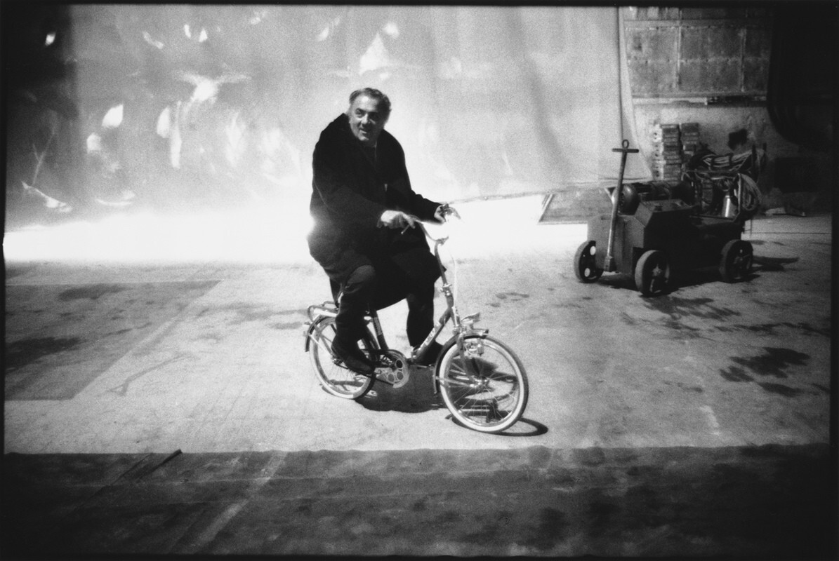 В соответствии с комическим тоном фильма, Феллини катается по парку на детском велосипеде. Амаркорд, Рим, Италия, 1970 г. За кулисами. Фотограф Мэри Эллен Марк