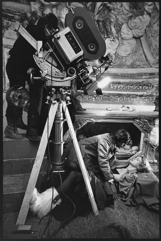 Лина Вертмюллер смотрит в камеру на любовную сцену между Джанкарло Джаннини и Кэндис Берген. Ночь, полная дождя, Рим, Италия, 1977 год. За кулисами. Фотограф Мэри Эллен Марк