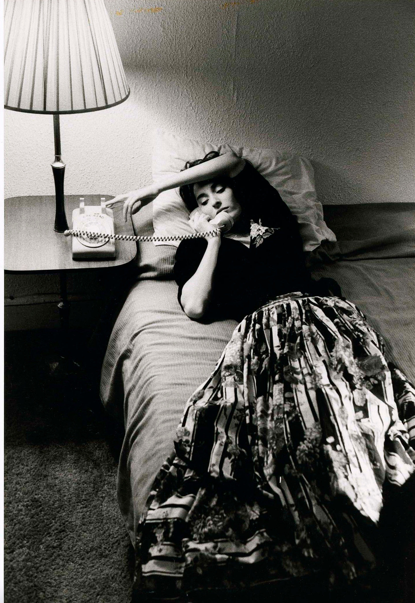 Женщина лежит на кровати с телефоном в руке, 1986 г. Фотограф Дэвид Сайднер