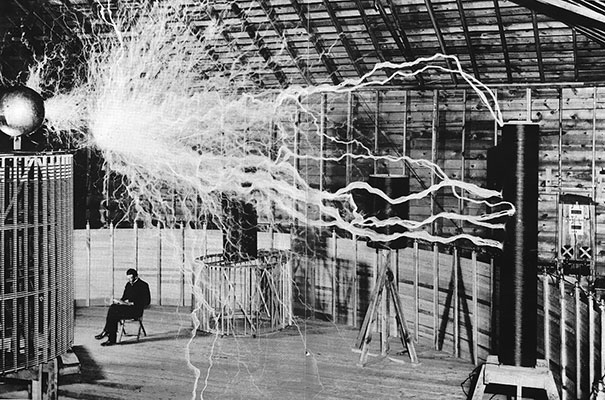 Никола Тесла сидит в своей лаборатории